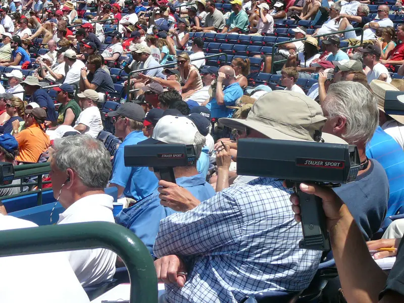 Baseball scouts in the stands holding older Stalker Sport radar guns